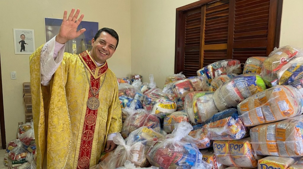 Padre com doação de cestas básicas